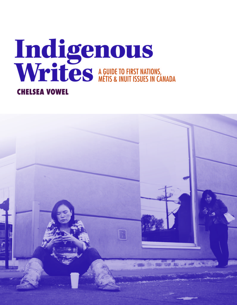 The cover of Indigenous Writes, A Guide to First Nations, Métis and Inuit Issues in Canada. Jennifer Podemski sits on a sidewalk outside a building, wearing mukluks and looking at her smartphone, a cup of coffee between her feet. Another woman leans against the building checking her phone.